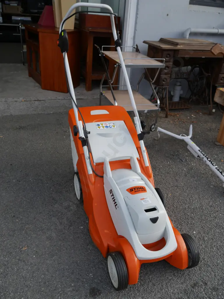 Stihl electric mower, battery and charger in office Image 1++